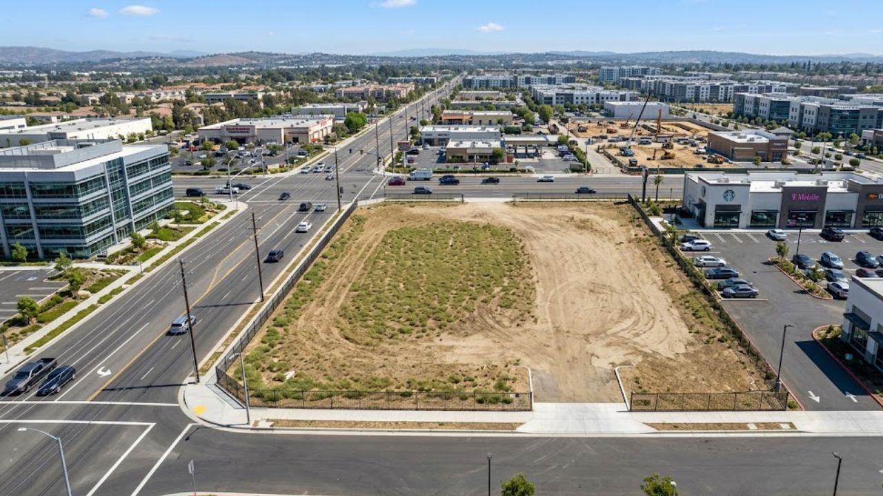 Aerial view of a vacant commercial parcel at an established intersection.